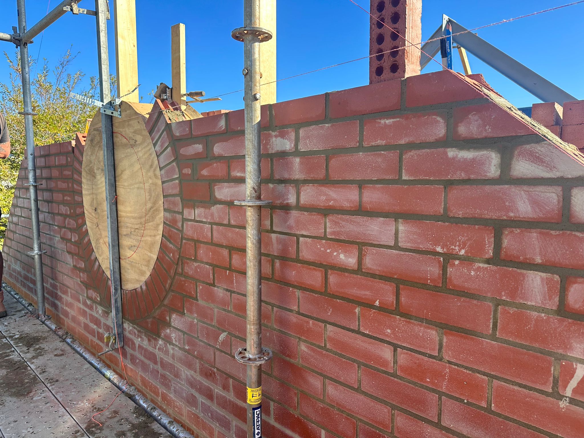 Stage 1 of custom circular window design — initial setting out and first brick courses