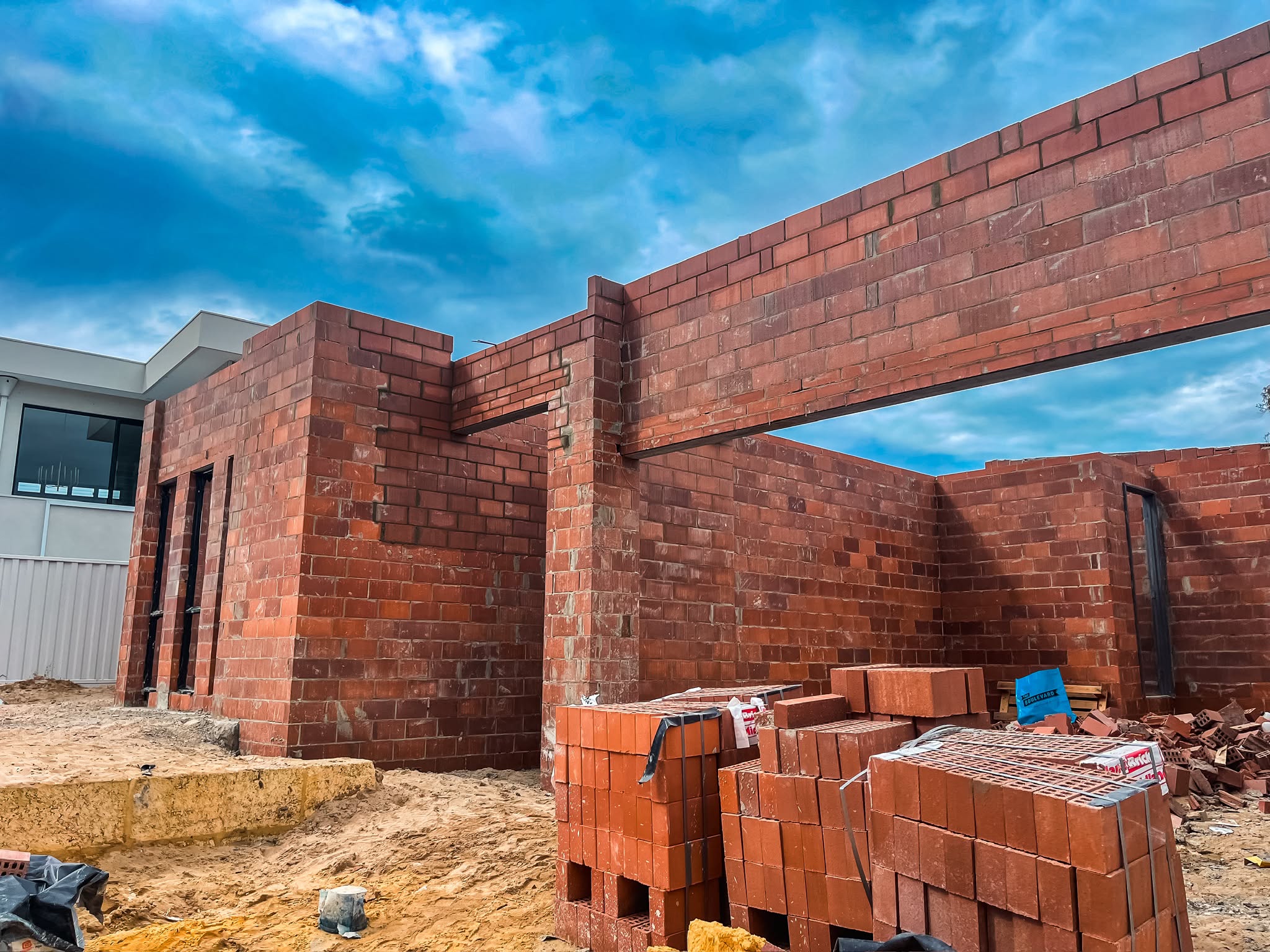 Red brick walls with a large square window opening framed against blue sky